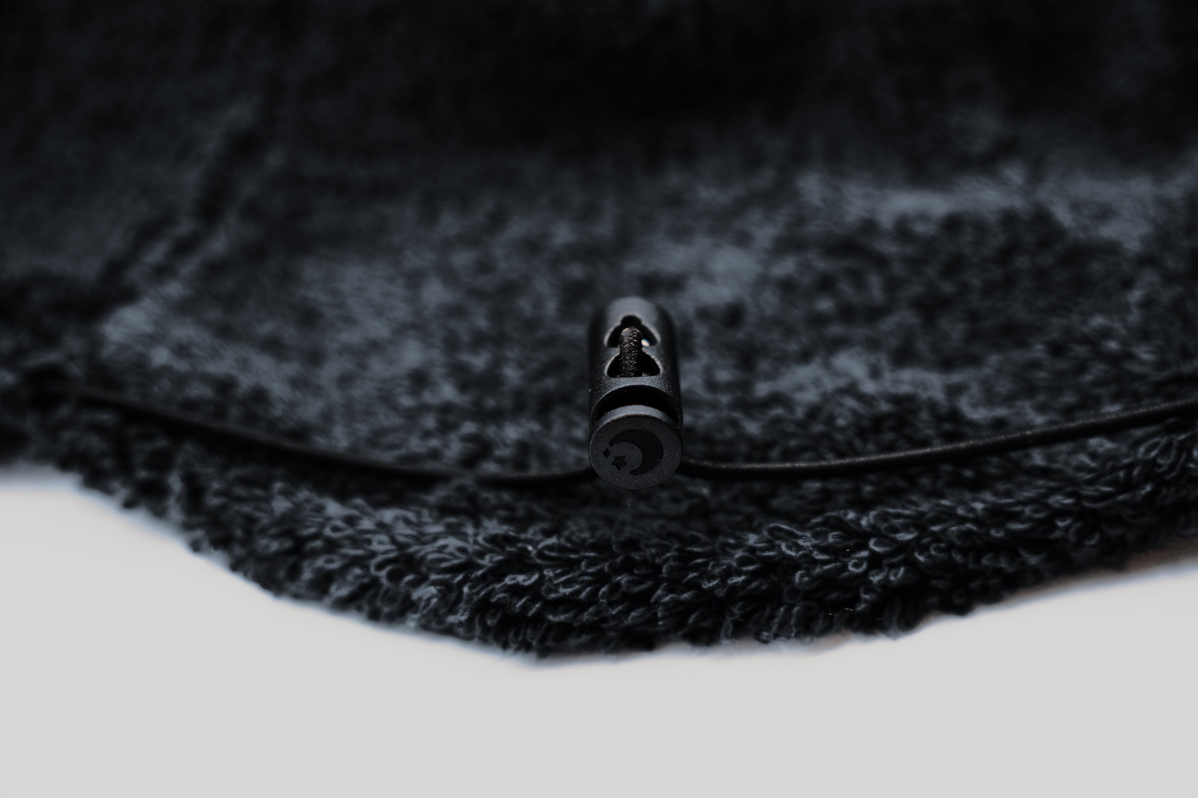 Crescent-marked rear drawcord stopper of the Sweat Hat